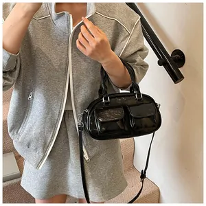 Detail shot of black patent leather hobo bag with front pockets and silver hardware
