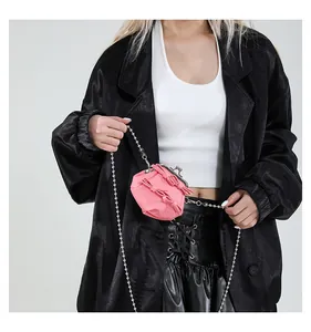 Nahaufnahme einer rosa Mini-Tasche mit 3D-Schleifen, Klippverschluss und Silberkette