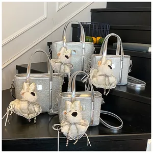 Detailed view of silver glitter bucket bags with plush puppy charms on a display stand