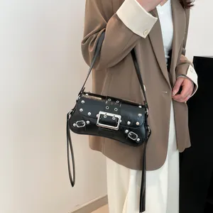 Sac bandoulière rétro noir clouté avec boucle en métal porté par un mannequin femme