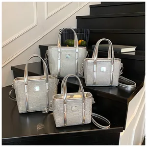 Detailset aus vier silbernen Pailletten-Eimertaschen in verschiedenen Größen mit Metallgriffen