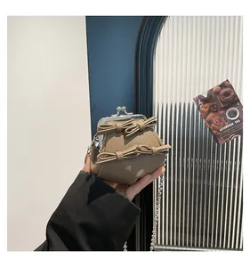 Detail der khakifarbenen Mini-Tasche mit Schleifen und silbernem Klickverschluss