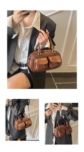 Close-up of vintage brown gloss leather bag showing front pockets and zipper detail