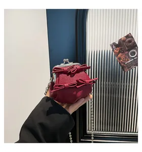 Detail der weinroten Mini-Tasche mit Schleifen, Kieselleder und silberner Kette