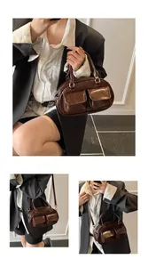 Macro detail of dark brown glossy leather handbag showing dual front pockets and metallic finish
