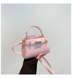Detail of pink leather handbag with silver square buckle and detachable shoulder strap