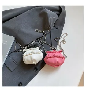 Detail von rosa und weißen Mini-Schleifentaschen mit Litschi-Struktur und Perlenketten