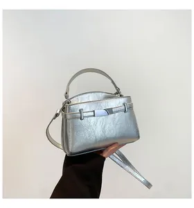 Close-up of metallic silver handbag with textured faux leather and adjustable strap
