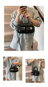 Detail of black patent leather hobo bag featuring dual front pockets and glossy finish