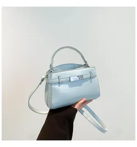 Close-up of light blue synthetic leather handbag showing fine litchi texture and metal buckle