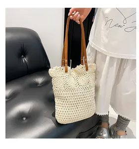 Close-up of cream woven tote bag with intricate knit patterns and brown leather straps