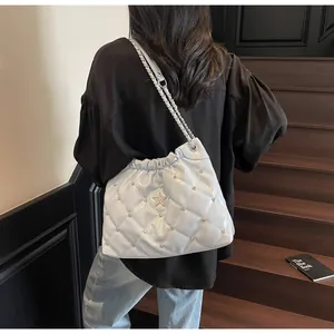Détail du sac seau matelassé bleu clair avec rivet étoile et bandoulière en chaîne