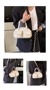 Detailed close-up showing dual front pockets and glossy leather of the cream underarm bag