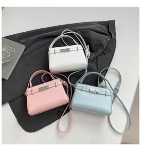 Detailed shot of trendy trapezoid handbags in white, pink and blue with metal locks