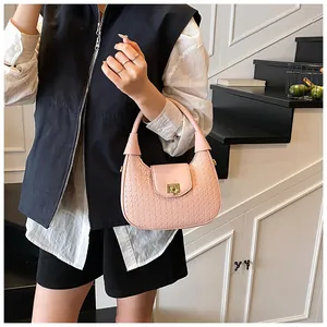 Close-up of pink woven hobo bag featuring a refined gold square metallic buckle lock