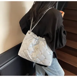 Détail du sac seau matelassé bleu clair avec clous argentés et emblème étoile