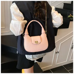 Pink woven texture crescent bag with gold chain strap shown on a model's shoulder