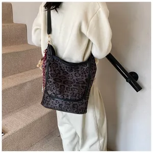 Detail of leopard print tote bag with adjustable strap and decorative ribbon pendant