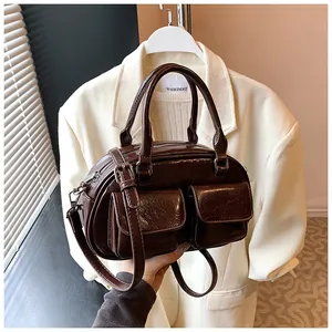 Detail of vintage coffee shoulder bag featuring dual front pockets and glossy wax leather texture