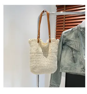 Close-up of beige crochet tote bag with flower pattern and brown leather straps
