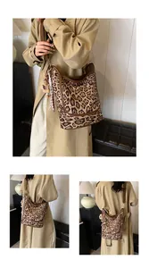 Detailed leopard print tote with brown leather edges, bear pendant and striped scarf detail