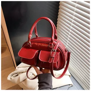 Detailed view of red retro underarm bag with glossy finish and double front pockets
