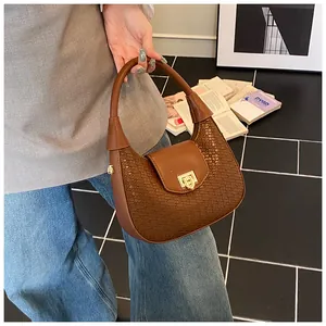 Close-up of brown woven leather hobo bag with elegant gold metal twist lock buckle