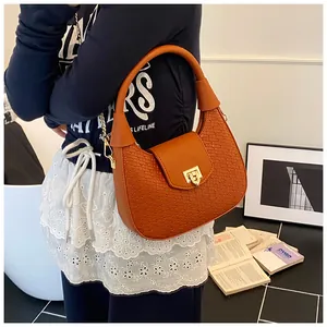 Detail of orange woven hobo bag showing intricate texture and golden metal buckle