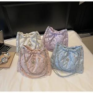 Vue de quatre sacs seaux matelassés pastel avec étoile en strass et détail de chaîne argent