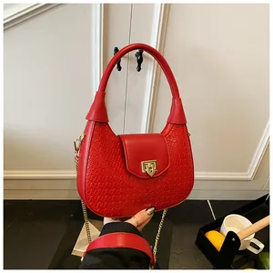 Close-up of red crocodile-patterned crescent bag with gold chain and metal buckle