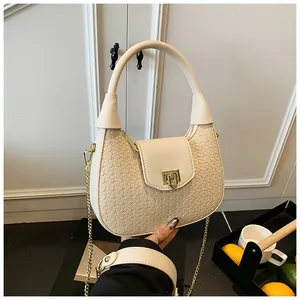 Detail of cream woven hobo bag showing gold twist lock and fine braided texture