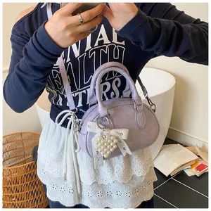 Detail view of mini lavender leather bowling bag with pearl heart charm and lace bow