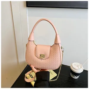 Detail of a pink woven handbag featuring a smooth leather flap and golden metal clasp