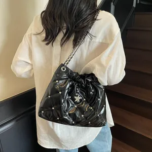 Sac seau matelassé noir avec étoile argentée et bandoulière chaîne sur modèle