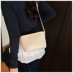 Detailed macro view of beige bucket bag with woven texture and adjustable strap