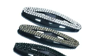 Close-up of three crystal-studded oval hair clips in white, grey, and green colors