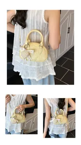 Detail view of yellow crossbody bowling bag with pearl heart charm and lace bow decor