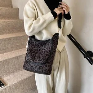 Chic leopard print tote bag for women with adjustable strap in minimalist indoor setting