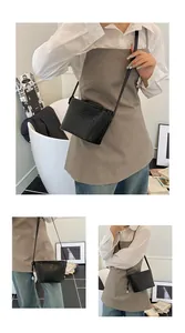 Detail of woven black leather texture on crossbody bag with silver sphere hardware