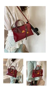 Detailed view of burgundy leather handbag with polka dot silk scarf and gold twist lock