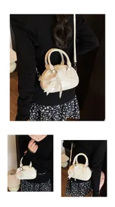 Detail of cream white mini bowling bag with lace bow, pearl charm and wrinkled leather