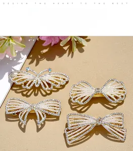 Dettaglio di eleganti fermagli in lega dorata con perle bianche e strass di cristallo