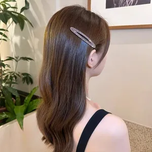 Sparkling rhinestone oval BB hair clip worn by a model for a stylish side fringe look