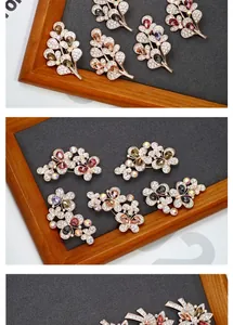 Detailed close-up of crystal flower brooches in rose gold finish on a velvet display tray
