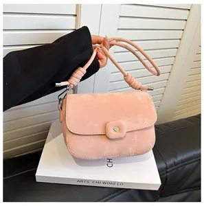Detailaufnahme der rosa Wildledertasche mit Herzschnalle und geknotetem Seilriemen