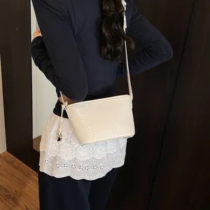 Women's off-white woven leather crossbody bucket bag with elegant shoulder strap