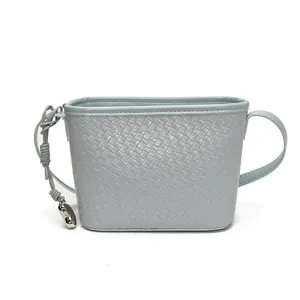 Blue woven texture bucket bag with a stylish silver heart pendant on white background