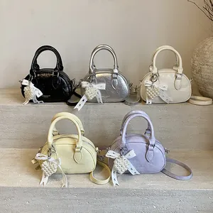 Mini cylindrical bowling bags in five colors on stone steps with heart charms