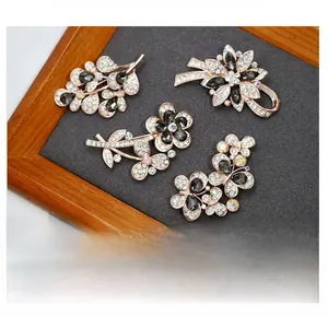 Macro detail of rose gold crystal brooches featuring floral and butterfly motifs