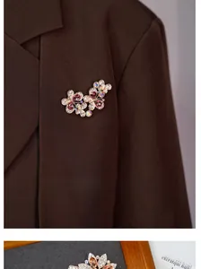 Detail of vintage crystal butterfly floral brooch with pink gemstones on suit lapel